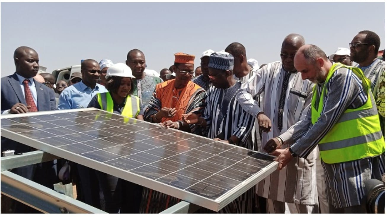 Visitors gathered around a solar photovoltaic module during a site visit